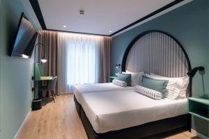 a bedroom with a large bed and a television at Vincci Bonjardim in Porto