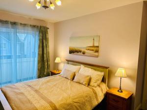 ヴァレンティア島にある7 Knightshaven Holiday Village, Valentia Islandのベッドルーム1室(ベッド1台付)、窓(灯台付)