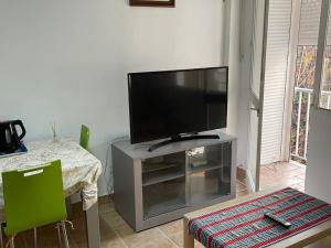 a living room with a flat screen tv on a entertainment center at Cosy apartment with shared balcony in Seville