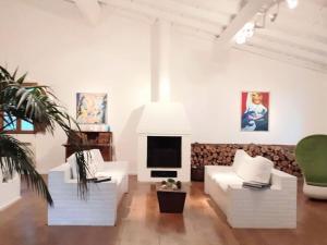 Elle comprend un salon doté d'un mobilier blanc et d'une cheminée. dans l'établissement Holiday home Bomorto, à Calenzana