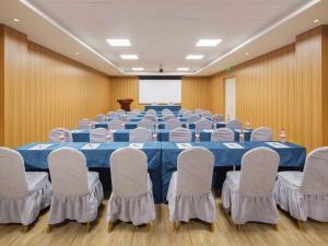 ein großer Konferenzraum mit einem blauen Tisch und Stühlen in der Unterkunft Vienna Hotel Ulan Qab New District High-Speed Railway Station in Pingdiquan