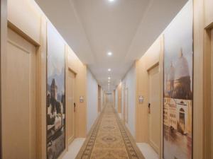 un corridoio con dipinti sulle pareti di un edificio di Vienna Hotel Shanghai Hongqiao Hub National Exhibition Center Huqingping Road a Shanghai