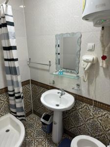 La salle de bains est pourvue d'un lavabo, de toilettes et d'un miroir. dans l'établissement Hotel Ravshan Boutique, à Boukhara