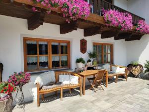 - une terrasse avec une table, des chaises et des fleurs dans l'établissement Attractive apartment in Bavaria, à Schöllnach