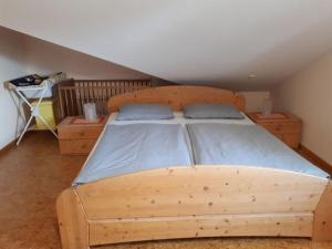 - une chambre avec un lit en bois et des draps bleus dans l'établissement Attractive apartment in Bavaria, à Schöllnach