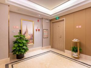 a hallway with a door and a potted plant at Vienna Hotel Chaozhou River View in Chaozhou