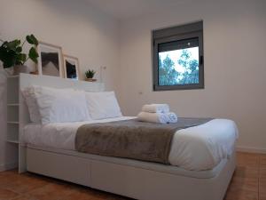 een slaapkamer met een bed met twee handdoeken erop bij Cantinho dos Avós - Country House in Sever do Vouga