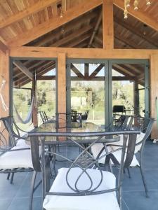 un tavolo in vetro e sedie su un patio di Altos de Huellahue a Panguipulli