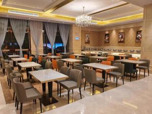 um restaurante com mesas e cadeiras e um lustre em Vienna Hotel Guangdong Shaoguan Shaonan Avenue em Shaoguan