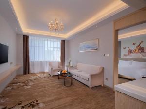 uma sala de estar com um sofá e um lustre em Vienna Hotel Guangdong Shaoguan Shaonan Avenue em Shaoguan