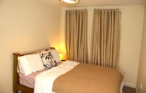 - une petite chambre avec un lit et des rideaux dans l'établissement Spacious 2BR flat in Central London near Elephant and Castle station, à Londres