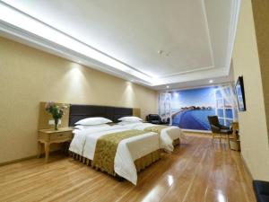 a hotel room with two beds and a large window at Vienna Hotel Shandong Yantai Wanda Plaza Suochengli in Yantai