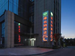 a building with neon signs on the side of it at Vienna Hotel Shandong Liaocheng High-Tech Zong Yueji Park in Liaocheng