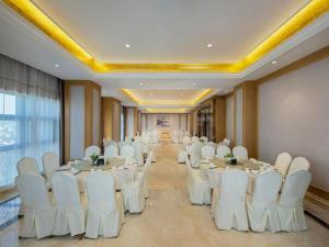 a banquet hall with white tables and white chairs at Vienna Hotel Shaanxi Hanzhong Central Square High-Speed Railway Station in Hanzhong