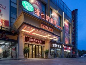 um edifício com sinais de néon na lateral em Vienna Hotel Guangxi Beihai High-Speed Railway Station em Dianbailiao