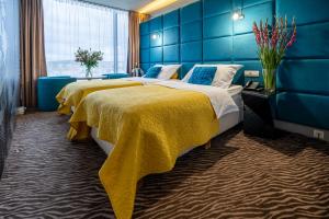 2 letti in una camera d'albergo con pareti blu di Sono Hotel a Brno