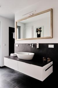 uma casa de banho com um lavatório branco e um espelho. em Hotel BalthazarS em Seligenstadt