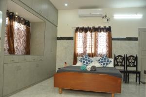 a bedroom with a bed with blue and white pillows at Roof-top stay in centre of city in Thanjāvūr