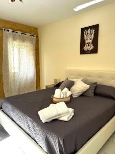 een slaapkamer met een bed met twee handdoeken erop bij L’Angolo Degli Dei in Agrigento