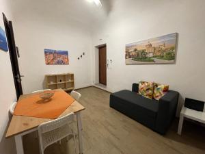 a living room with a table and a couch at Le Colonne del Massimo Apartment in Palermo