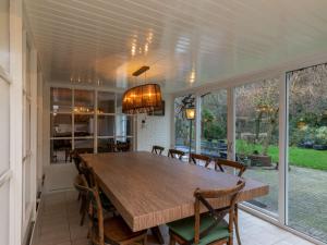 - une salle à manger avec une table et des chaises en bois dans l'établissement Charming thatched beach villa with garden, à Biggekerke