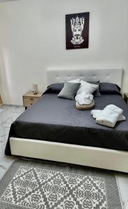 a bedroom with a large bed with black sheets and pillows at L’Angolo Degli Dei in Agrigento