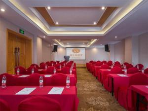 Vienna Hotel Chongqing Wanzhou Wanda Plaza في Wanxian: قاعة اجتماعات بها طاولات وكراسي حمراء