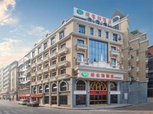 Vienna Hotel Chongqing Wanzhou Wanda Plaza في Wanxian: مبنى كبير على زاوية شارع