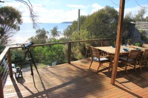 a camera on a deck with a table and the ocean at Emu Bay Stay in Emu Bay