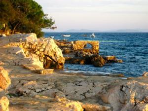 eine felsige Küste mit Booten im Wasser in der Unterkunft Charming apartment in Vodice in Ždrelac