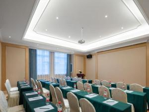 uma sala de conferências com mesas e cadeiras verdes em Vienna Hotel Chongqing Lijiatuo Pedestrian Street em Nanwenquan