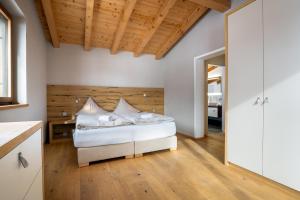 a bedroom with a bed with a wooden wall at Ski & Golf Auszeit Apartment by Alpine Host Helpers in Kitzbühel