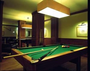 a pool table in a living room with a light at Hotel Pacsirta in Sovata