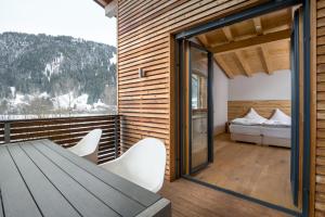 a room with a table and chairs and a bed at Ski & Golf Auszeit Apartment by Alpine Host Helpers in Kitzbühel