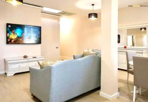 een woonkamer met een blauwe bank en een tv bij Next Apartments Constanta in Constanţa