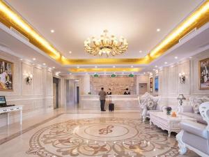a man standing in a large room with a chandelier at Vienna Hotel Xuzhou Junsheng Plaza Benteng Avenue Metro Station in Xuzhou