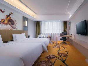 a hotel room with two beds and a flat screen tv at Vienna Hotel Xuzhou Junsheng Plaza Benteng Avenue Metro Station in Xuzhou