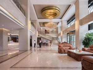una hall con divani e lampadario pendente in un edificio di Venus International Hotel Guangdong Huizhou West Lake a Huizhou