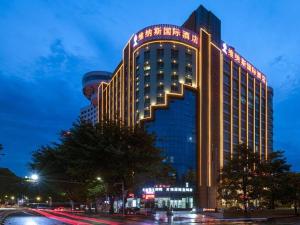 恵州市にあるVenus International Hotel Guangdong Huizhou West Lakeの夜間照明付きの大きな建物
