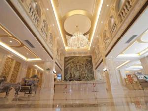een grote lobby met een kroonluchter en een groot schilderij bij Vienna Hotel Shenyang Central Street in Shenyang