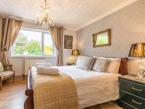a bedroom with a large bed and a chandelier at 6 Bed in Buckland Brewer SWOLD in Buckland Brewer