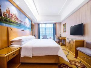 - une chambre avec un grand lit et une télévision à écran plat dans l'établissement Vienna Hotel Hunan Yueyang Linxiang, à Linxiang
