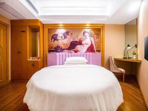 - une chambre avec un grand lit et une peinture murale dans l'établissement Vienna Hotel Hunan Yueyang Linxiang, à Linxiang
