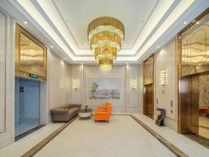 a living room with orange chairs and a chandelier at Vienna Hotel Fuzhou Mawei in Mawei