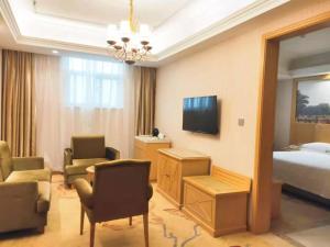 a hotel room with a bed and a tv at Vienna Hotel Hubei Xiangyang Tang City Gulou in Xiangyang