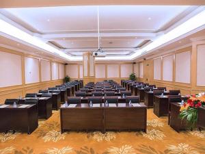 uma grande sala com fileiras de mesas e cadeiras em Vienna Hotel Hubei Xiangyang Tang City Gulou em Xiangyang