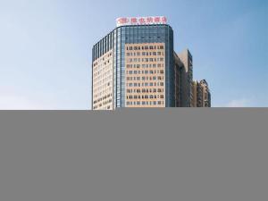 un edificio alto con un cartel encima en Vienna Hotel Guangdong Dongguan Chengnan Station, en Huangcun