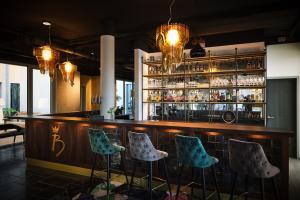 Eine Bar mit vier Barhockern vor einem Tresen in der Unterkunft Hotel BalthazarS in Seligenstadt