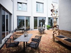 un patio con mesas y sillas y un edificio en Hotel BalthazarS en Seligenstadt