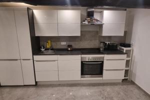 a kitchen with white cabinets and a stove top oven at Private Apartment in Ronnenberg